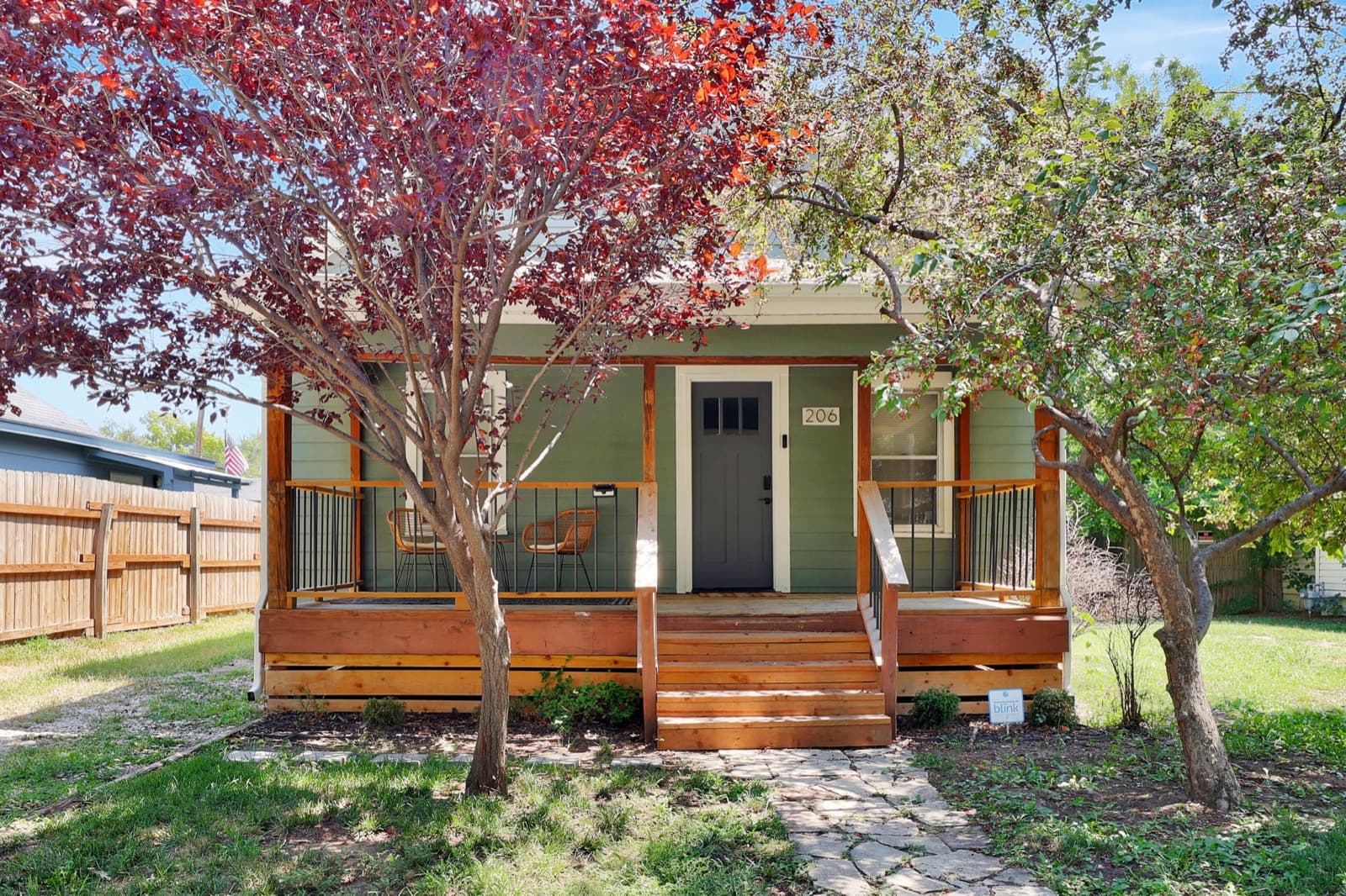 A green bungalow with a front porch, one of the homes on Goldilocks